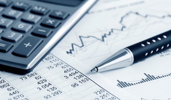 Bilan comptable, stylo et calculatrice illustrant le métier des experts comptables