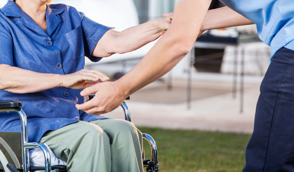 Gestes-Postures-manutention-PMR-Sensibilisation-AISMT13 Personne aidant une autre en fauteuil roulant pour illustrer les techniques gestuelles de manutention adaptées aux PMR