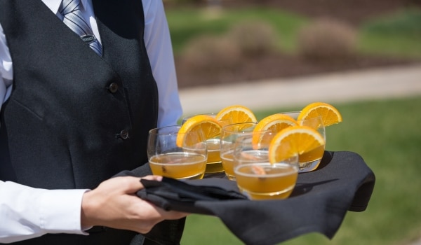 Serveur portant un plateau de boissons pour représenter les salariés saisonniers