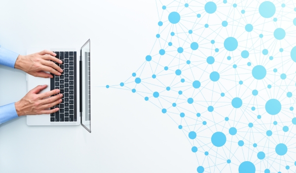 Ordinateur dont sort des réseaux pour représenter l'hyperconnexion au travail