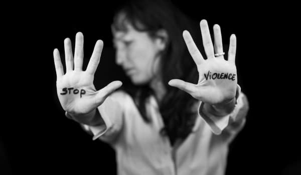 Femme qui tend les mains sur lesquelles est écrit "stop violences"