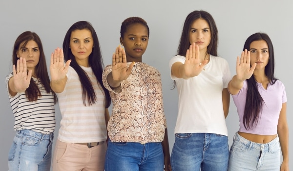 Femme qui font signe de la main pour dire stop sexisme et au harcèlement sexuel au travail