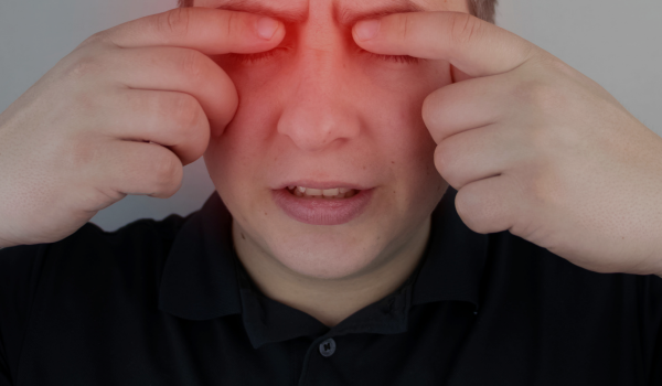 Homme qui se frotte les yeux illustrant la conduite à tenir en cas de projections oculaires