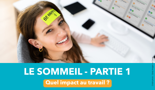 Vidéo sommeil travail – partie 1 – AISMT13 Femme souriante à un bureau avec un post-it sur le front sur lequel il est écrit "be happy" afin d'illustrer une vidéo sur l'impact du sommeil au travail