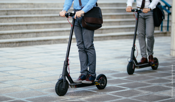 Deux travailleurs sur des trottinettes électriques afin d'illustrer un webinaire sur les EDPM